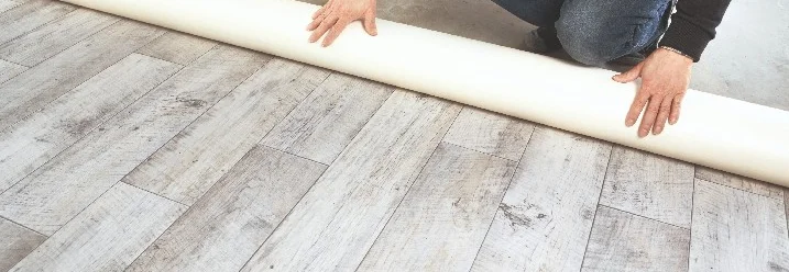 Person rollt einen PVC-Boden aus